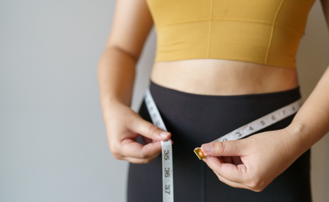 a woman who is measuring after her progress with the help of honey for weight management